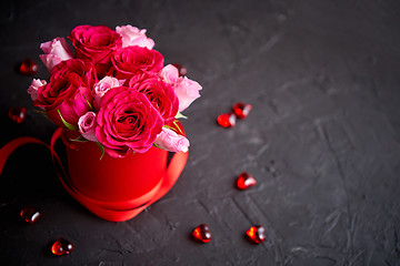 Image showing Pink roses bouquet packed in red box and placed on black stone b