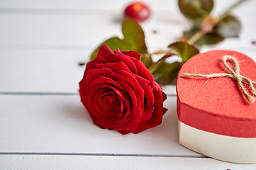 Image showing Fresh red rose flower on the white wooden table