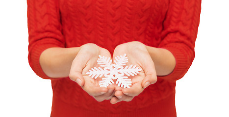 Image showing close up of woman in red sweater holding snowflake