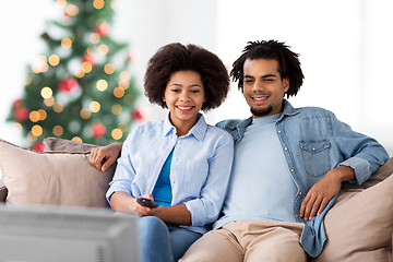 Image showing happy couple watching tv at home on christmas