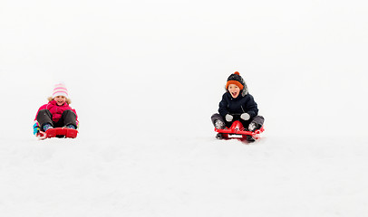 Image showing kids sliding on sleds down snow hill in winter