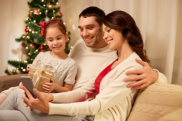 Image showing family with smartphone at home on christmas