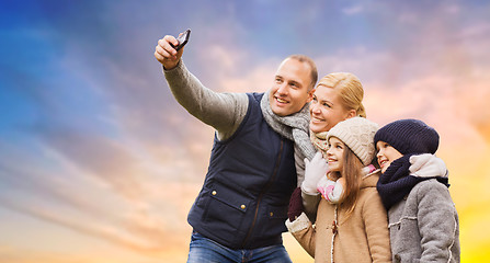 Image showing family taking selfie by smartphone over sky