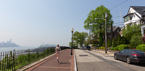 Image showing Healthy lifestyle. Woman is jogging on Hamilton ave by Hamilton park, New Jersey. Manhattan of New York City in the background.