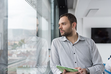 Image showing Businessman Using Tablet In Office Building by window