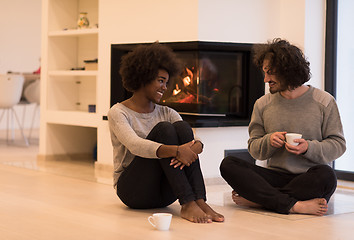 Image showing multiethnic couple  in front of fireplace