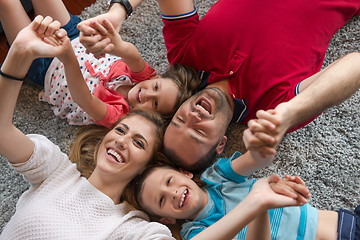 Image showing happy family lying on the floor