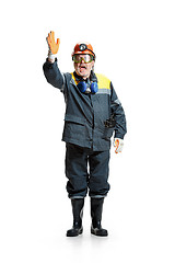 Image showing The studio shot of senior bearded male miner standing at the camera on a white background.