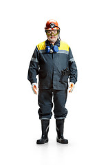Image showing The studio shot of serious senior bearded male miner standing at the camera on a white background.