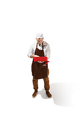 Image showing Serious butcher posing with a laptop isolated on white background