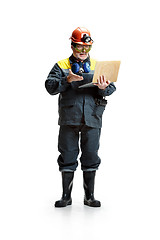 Image showing The studio shot of serious senior bearded male miner standing at the camera with laptop on a white background.