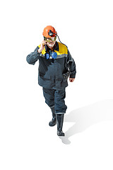 Image showing The studio shot of senior bearded male miner standing at the camera on a white background.