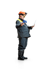 Image showing The studio shot of happy senior bearded male miner standing in profile view at the camera with laptop on a white background.