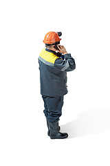 Image showing The studio shot of senior bearded male miner standing at the camera on a white background.