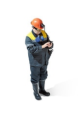 Image showing The studio shot of senior bearded male miner standing at the camera on a white background.