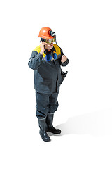 Image showing The studio shot of senior bearded male miner standing at the camera on a white background.