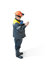 Image showing The studio shot of senior bearded male miner standing at the camera on a white background.