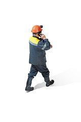 Image showing The studio shot of senior bearded male miner standing at the camera on a white background.