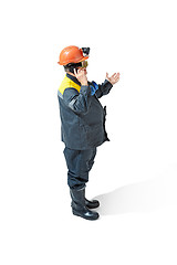 Image showing The studio shot of senior bearded male miner standing at the camera on a white background.