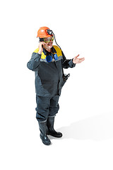 Image showing The studio shot of senior bearded male miner standing at the camera on a white background.