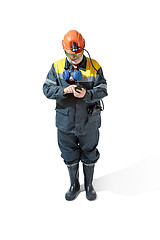 Image showing The studio shot of senior bearded male miner standing at the camera on a white background.