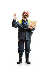 Image showing The studio shot of happy senior bearded male miner standing at the camera with laptop on a white background.