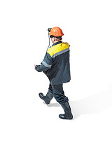 Image showing The studio shot of senior bearded male miner standing at the camera on a white background.