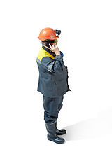 Image showing The studio shot of senior bearded male miner standing at the camera on a white background.