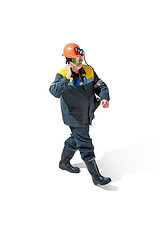 Image showing The studio shot of senior bearded male miner standing at the camera on a white background.