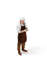 Image showing Smiling butcher posing with a cleaver isolated on white background