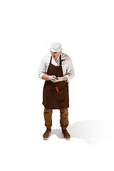 Image showing Smiling butcher posing with a cleaver isolated on white background