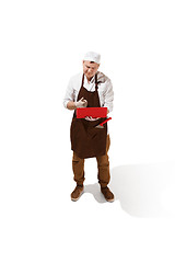 Image showing Serious butcher posing with a laptop isolated on white background