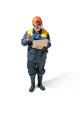 Image showing The studio shot of senior bearded male miner standing at the camera on a white background.