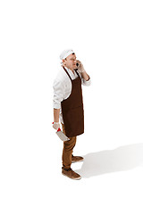 Image showing Smiling butcher posing with a cleaver isolated on white background