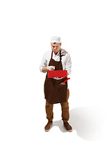 Image showing Serious butcher posing with a laptop isolated on white background