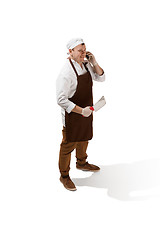 Image showing Smiling butcher posing with a cleaver isolated on white background