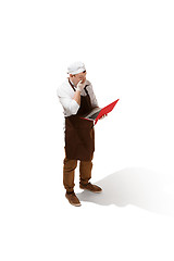 Image showing Serious butcher posing with a laptop isolated on white background