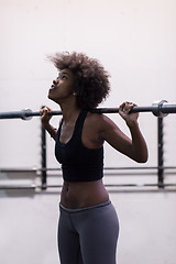 Image showing black woman lifting empty bar