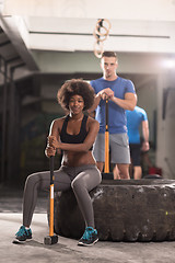 Image showing multiethnic couple after workout with hammer