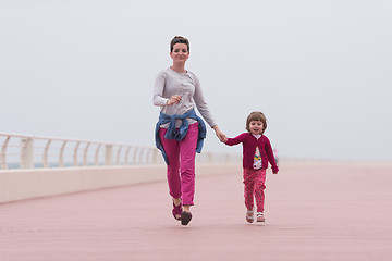 Image showing mother and cute little girl on the promenade by the sea