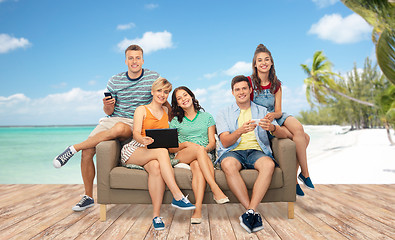 Image showing friends with tablet pc and smartphones over beach