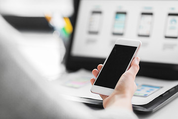 Image showing web designer with smartphone and laptop at office