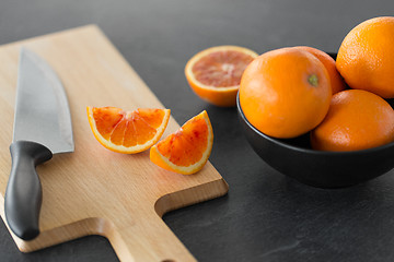 Image showing close up of oranges and knife on cutting board