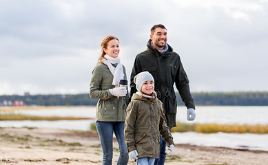 Image showing happy family walking along autumn beach