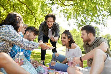 Image showing friends with drinks and food at picnic in park