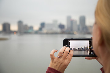 Image showing Woman Taking Pictures of The New Orleans Skyline with Her Smart 