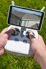 Image showing Hands Holding Drone Quadcopter Controller With Residential Roof 