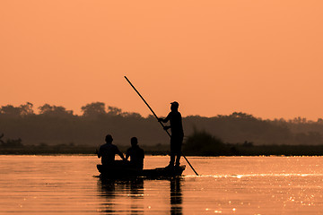 Image showing Men in a boat on a river silhouette