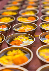 Image showing Buddhist flower offerings or gifts in bowls and rows