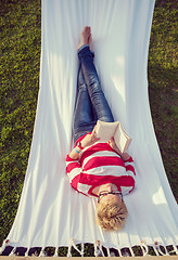 Image showing woman reading a book while relaxing on hammock